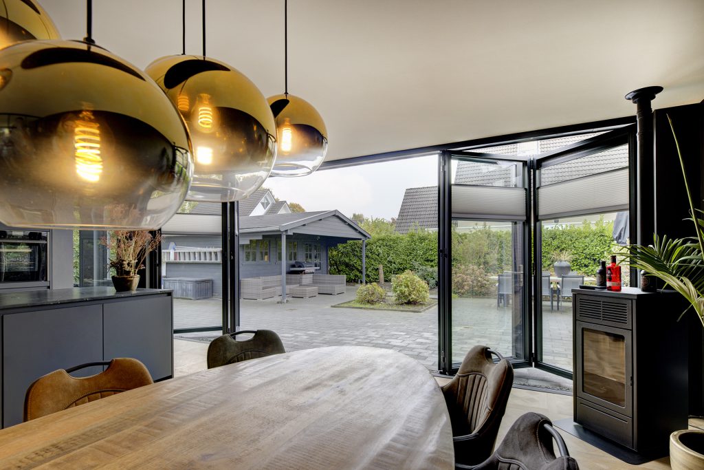 Geopende vouwwand met loopdeur en moderne keuken