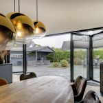 Geopende vouwwand met loopdeur en moderne keuken