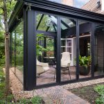 Moderne orangerie met donkergroene vouwwanden