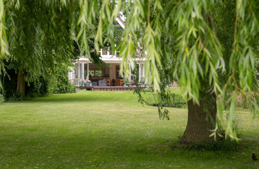 Serre op maat met aluminium vouwwand en zicht op achtertuin