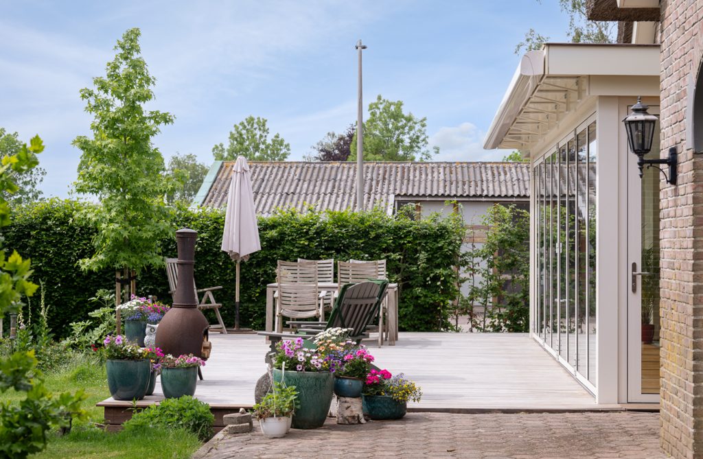 Lichtinval in serre met grote glaspartijen en groene omgeving