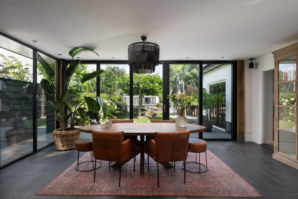 Moderne serreaanbouw in Nieuwersluis met glazen vouwwand en uitzicht op het water