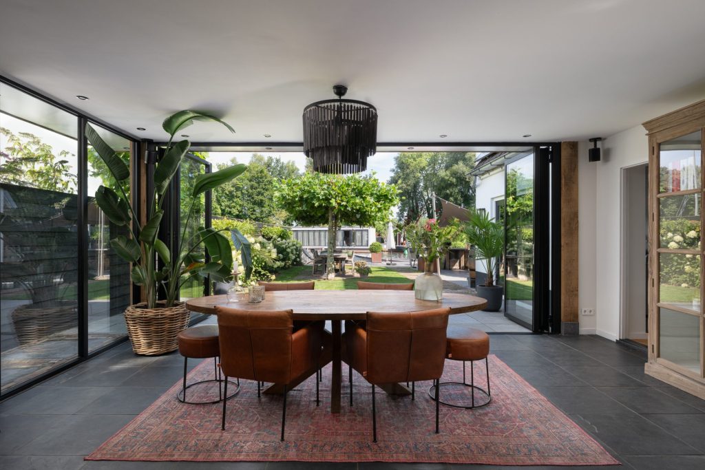 Zonnige serre met openslaande vouwwand, grenzend aan een rustige waterkant in Nieuwersluis