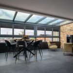 Moderne glazen serre als verlengstuk van de bovenverdieping