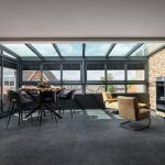 Moderne glazen serre als verlengstuk van de bovenverdieping