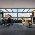Moderne glazen serre als verlengstuk van de bovenverdieping