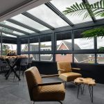 Moderne glazen serre als verlengstuk van de bovenverdieping