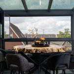 Moderne glazen serre als verlengstuk van de bovenverdieping