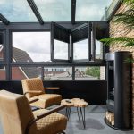 Moderne glazen serre als verlengstuk van de bovenverdieping