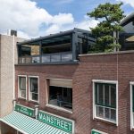 Moderne glazen serre als verlengstuk van de bovenverdieping