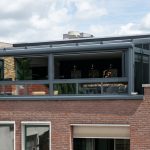 Moderne glazen serre als verlengstuk van de bovenverdieping