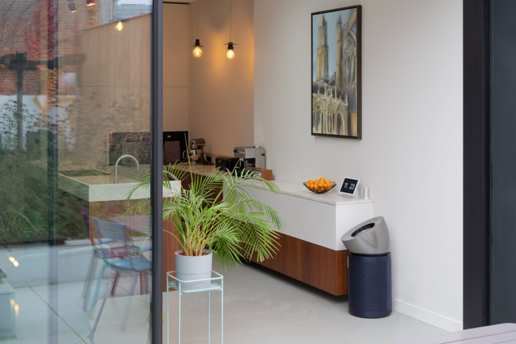 Minimalistische schuifpui van buitenaf met zicht op het lichte interieur