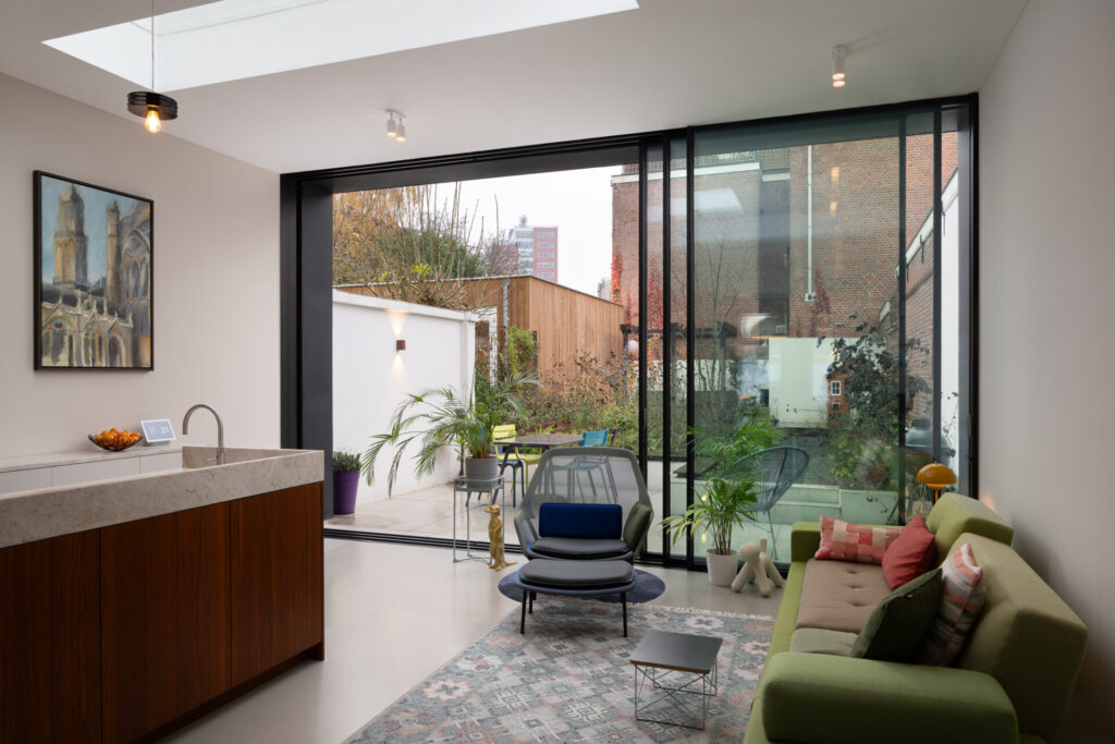 Interieur met lichte gietvloer en glazen pui die de tuin binnenhaalt