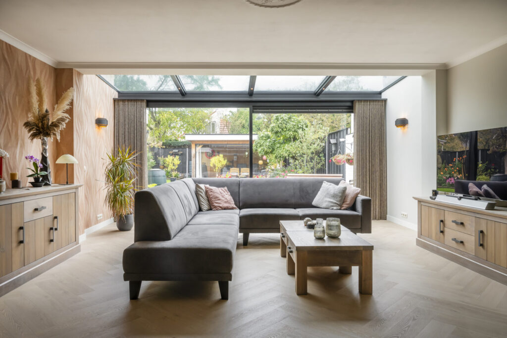 Moderne serre in Oldenzaal met een strak aluminium lessenaarsdak en grote glazen schuifpui.
