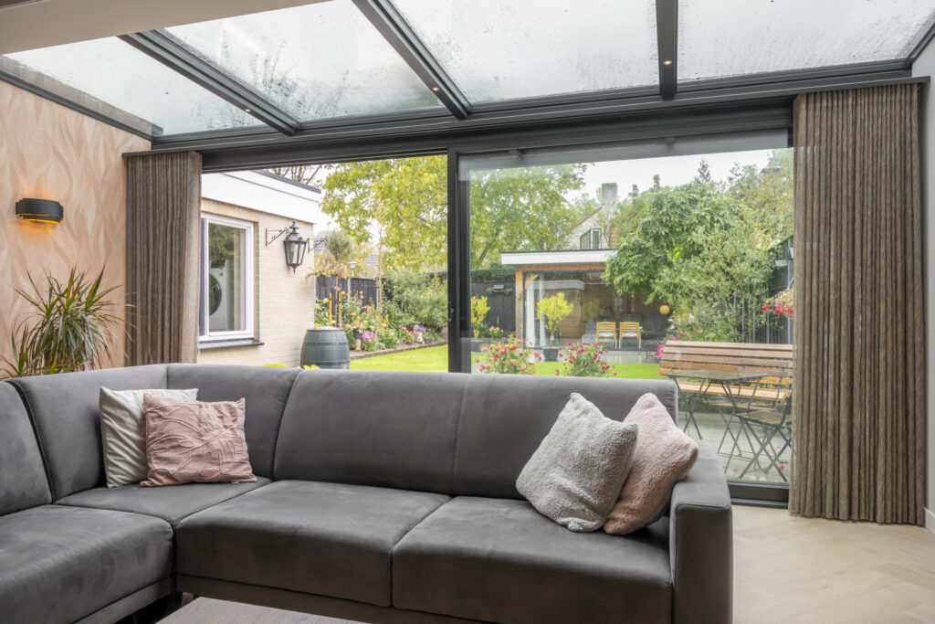 Binnenaanzicht van de vernieuwde serre met triple dakbeglazing en veel natuurlijke lichtinval.