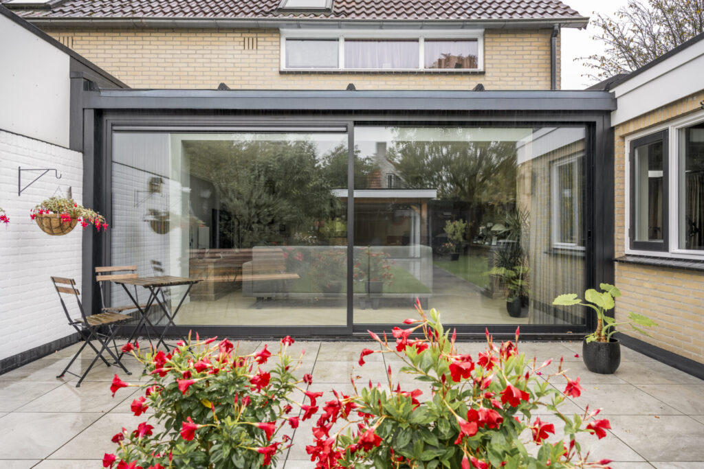 Nieuwe tweedelige aluminium schuifpui met uitzicht op de groene achtertuin.